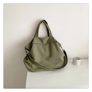 Détail d'un grand sac fourre-tout en nylon vert olive avec poignées et crochets en métal