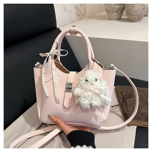 Détail du sac seau en cuir rose texturé avec fermoir argenté et breloque lapin