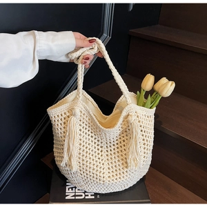 Détail d'un sac cabas en crochet blanc évidé avec franges et doublure pour la plage