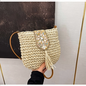 Detail of handmade straw crossbody bag with multi-colored beadwork and flowing fringe