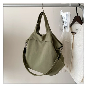 Détail du sac fourre-tout en nylon vert Morandi avec larges bretelles et crochets en argent