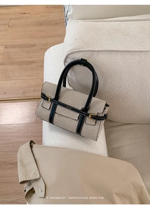 Dettaglio borsa retrò minimalista in tessuto beige intrecciato e finiture in pelle