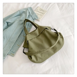 Détail du sac fourre-tout en nylon vert armée avec bandoulière réglable et tissu
