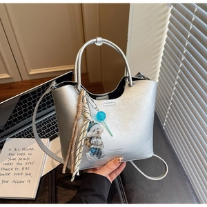 Détails du sac seau argenté avec pendentif chiot en peluche et pompons stylés et chic