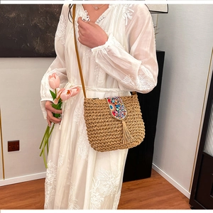 Detail of straw woven crossbody bag with colorful bead embroidery and decorative tassels