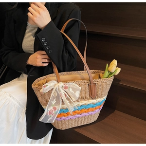 Detailed view of handmade woven straw bag with colorful stripes and lace flower bow