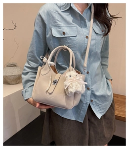 Détail du sac seau blanc cassé avec ruban à carreaux et breloque mouton en peluche