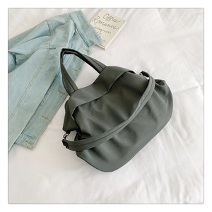 Vue détaillée du sac bandoulière en nylon gris foncé avec texture lisse et plis doux