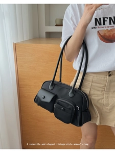 Detail of black multi-pocket retro shoulder bag with functional outer compartments