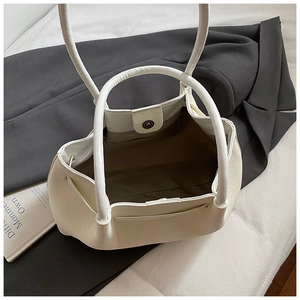 Close-up of beige woven tote bag interior with magnetic closure and zipper pocket