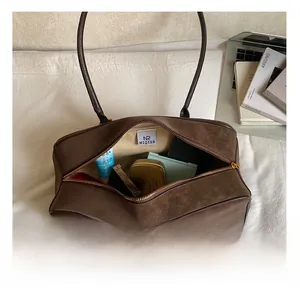 Spacious interior of brown suede bag showing room for daily essentials and lining