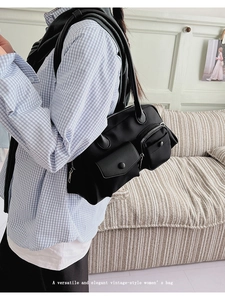 Detail of shoulder bag featuring double front flap pockets and silver metal zippers