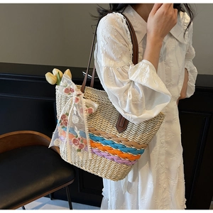 Detail of woven straw tote bag with colorful rainbow stripes and white lace bow decoration