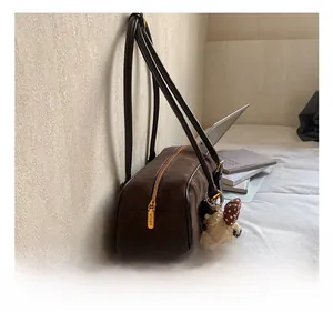 Detailed macro view of high-quality golden zipper hardware on brown suede handbag