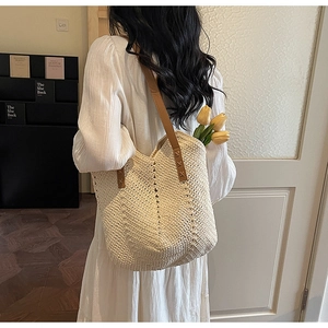 French style woven beach tote bag with brown leather straps shown on a model
