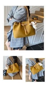 Detail of woven texture on mustard yellow tote bag with plush lamb charm and strap