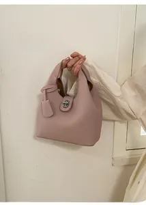 Detail of pink lychee grain leather handbag featuring a silver twist lock and hangtag