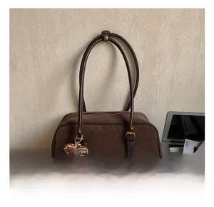 Detailed macro view of retro brown suede shoulder bag with a cute puppy plush pendant