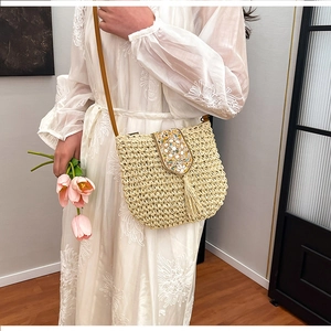 Bohemian woven straw shoulder bag with ethnic beadwork and fringe for beach vacation
