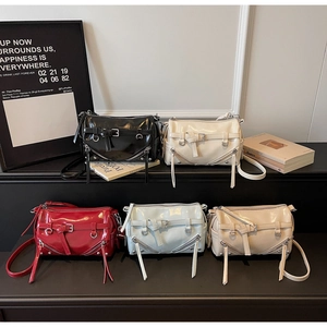 Close-up of gloss patent leather boston bags in multiple colors with metallic hardware
