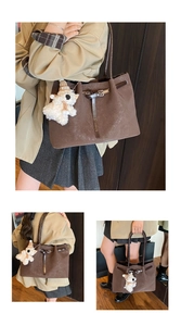 Close-up of a large vintage brown woven tote bag with a cute plush sheep charm