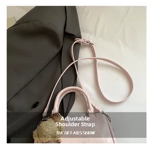 Detail view of pink crossbody pillow bag with adjustable strap and plush charm decor