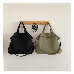 Détail d'un sac cabas en nylon minimaliste avec poignées et bandoulière réglable