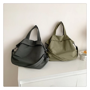 Vue détaillée de grands sacs en nylon olive et gris avec larges anses et bandoulières