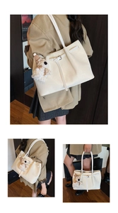 Detail of cream woven tote bag with leather texture and cute plush bear charm accessory