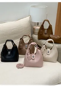 Close-up of litchi grain leather texture and metallic lock on minimalist bucket bags