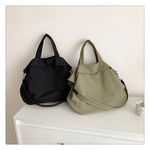 Détail de sacs fourre-tout minimalistes en nylon noir et vert olive avec bandoulière