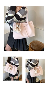Detail view of pink Saffiano leather tote bag featuring a cute teddy bear charm
