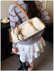 Detail showing vintage cream shoulder bag with brown trim and cute plush bear charm