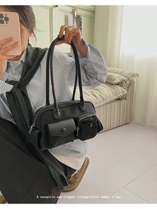 Detail of a black vintage utility shoulder bag with multiple functional pockets for women
