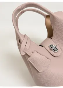 Detail of light pink lychee pattern leather bag with silver metal swivel lock