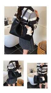 Three-side view of a large black woven tote bag with a plush bear charm for daily commute