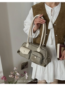 Detail of army green fabric shoulder bag with cream leather accents in vintage style