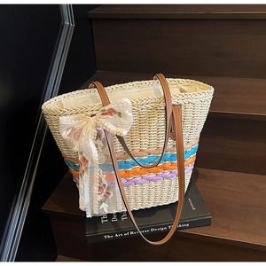 Detailed texture of handwoven straw tote with colorful stripes and lace flower bow detail