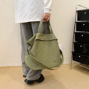 Détail d'un sac cabas en toile vert herbe avec poignée assortie et bandoulière réglable