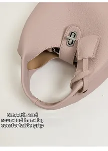 Close-up of pink litchi grain leather bag showing the silver turn-lock and rounded handle
