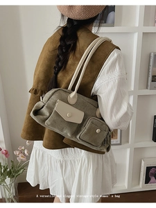 Detail of vintage-style canvas tote bag with contrast leather trim and side zipper pocket
