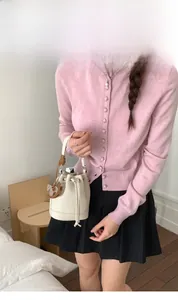 Detail of a beige lychee pattern bucket bag with a horse pendant and drawstring closure