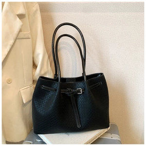 Detail of black woven tote bag with buckle strap and thin shoulder straps for work