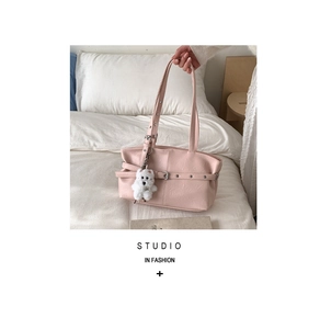 Detailed shot of pink faux leather tote bag featuring a cute white plush bear keychain charm