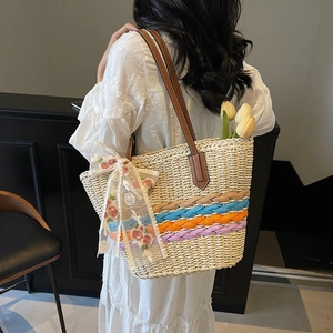Handmade woven straw tote bag with colorful stripes and floral lace bow for summer beach