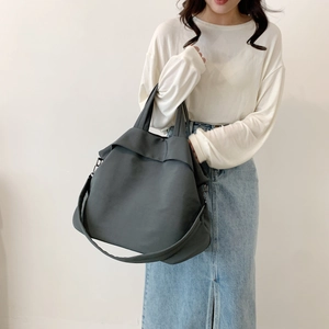 Vue détaillée du grand sac en nylon gris foncé montrant les crochets et poignées renforcées