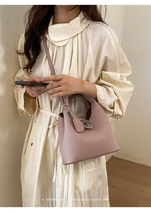 Detail of lychee pattern leather bucket bag with metal twist lock and crossbody strap