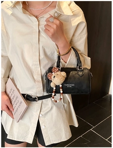 Detail of black mini Boston bag in matte PU leather with cute brown bear charm