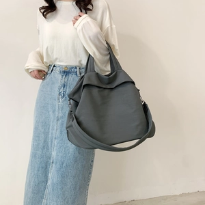 Grand sac cabas en nylon gris foncé porté par un mannequin pour un style décontracté