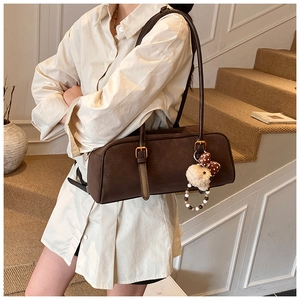 Detail view of coffee brown faux suede shoulder bag with plush puppy and bead chain charm